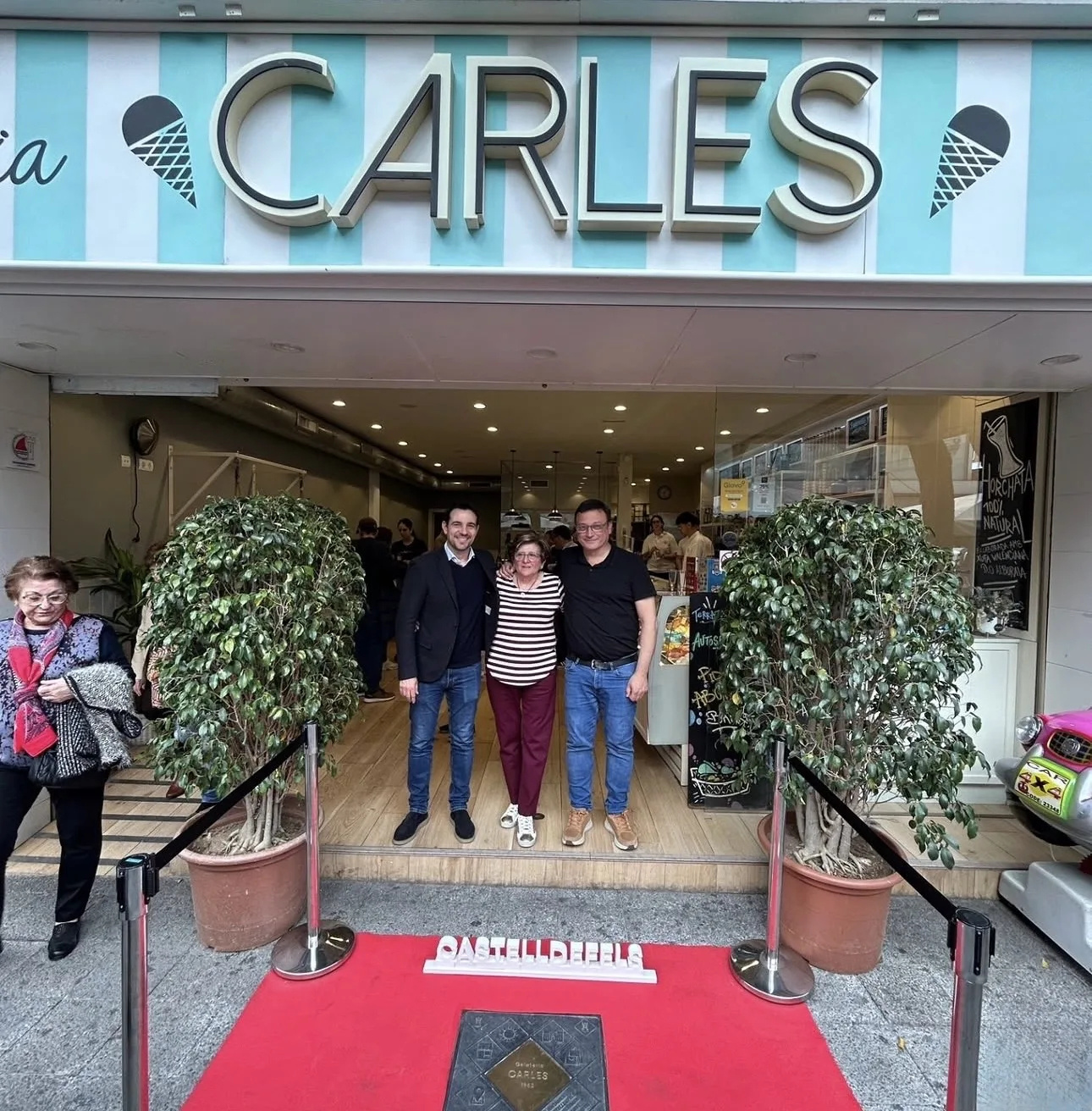 Familia de Gelateria Carles frente al local con la placa emblemática